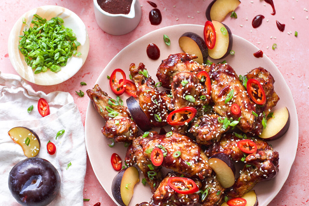 overhead image of sticky asian plum glazed chicken wings on a plate